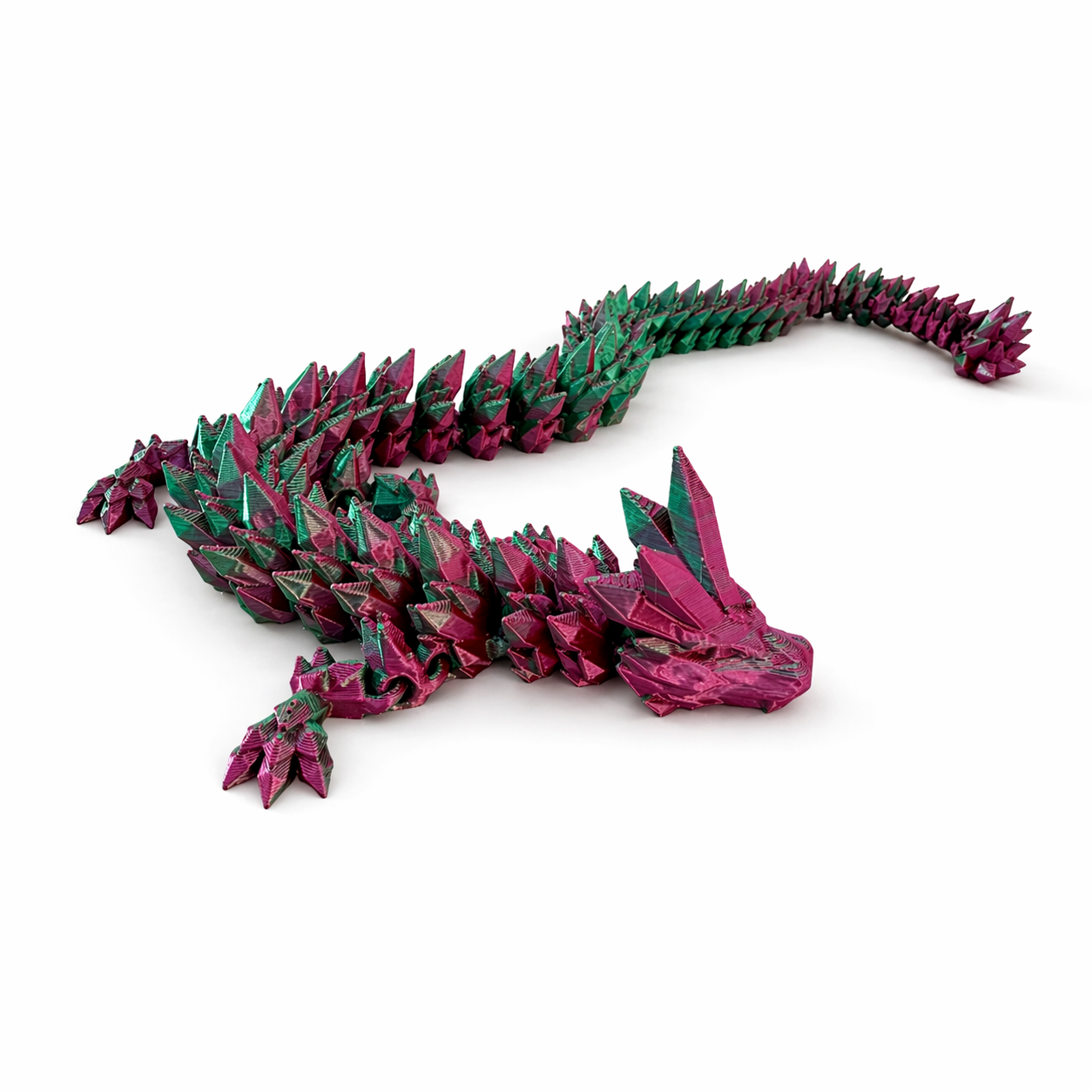 Articulated pink and green dragon toy posed on surface showing flexible segments and detailed features