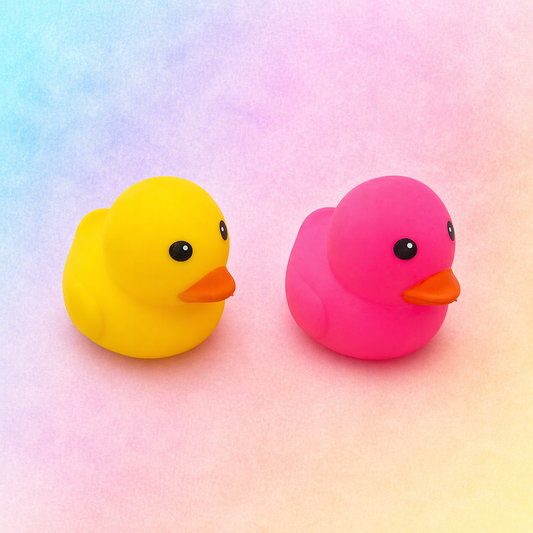 Pink and yellow large squishy ducks displayed together on pastel gradient background