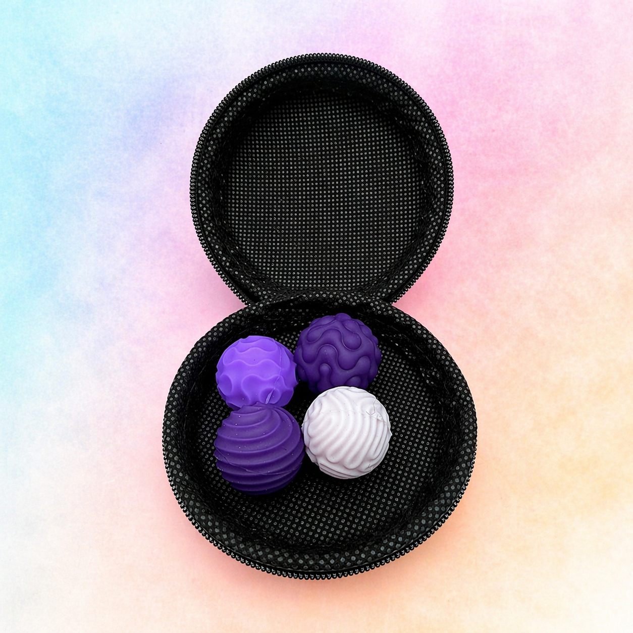 Magnetic sensory balls in a zip case with purple and white textured fidget balls on a soft gradient background