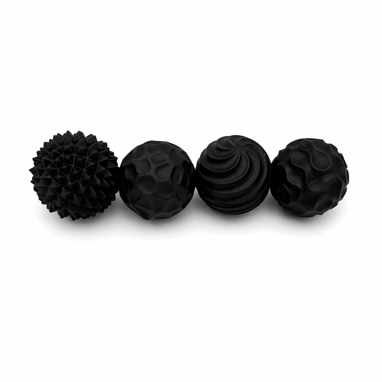 Black textured magnetic sensory balls lined up on a white background showing different tactile patterns