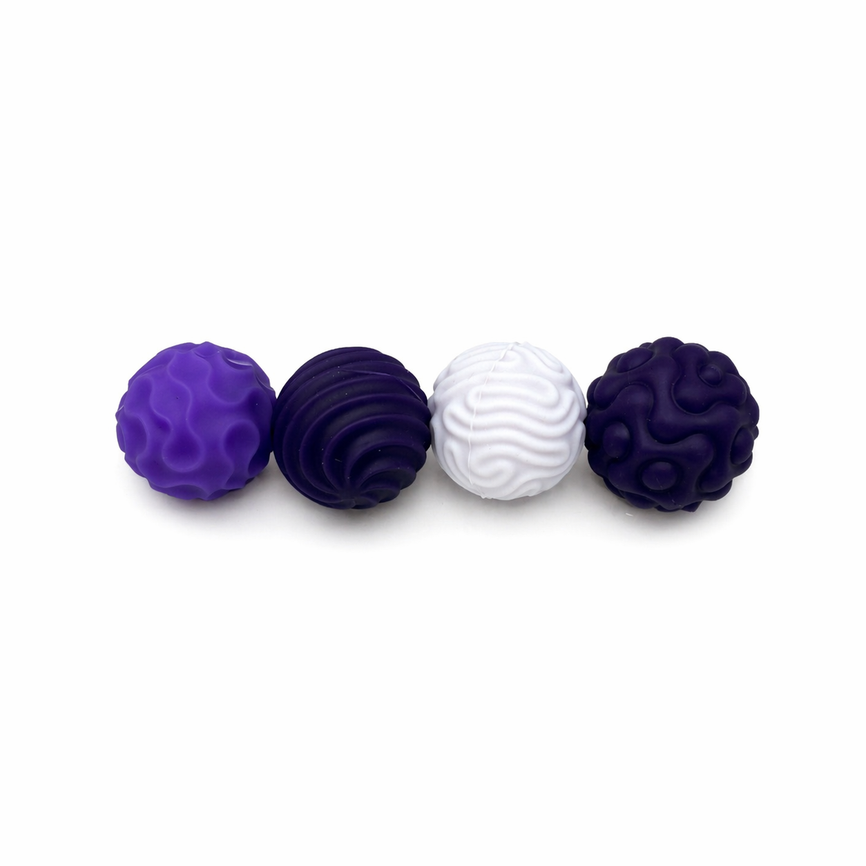 Purple and white textured magnetic sensory balls lined up on a white background showing varied tactile designs
